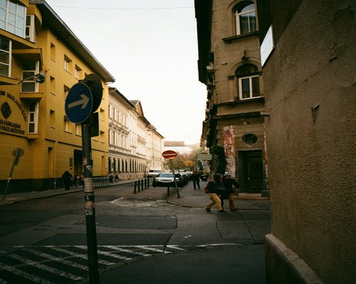 A person walking at a comfortable pace along a city street in Hungary